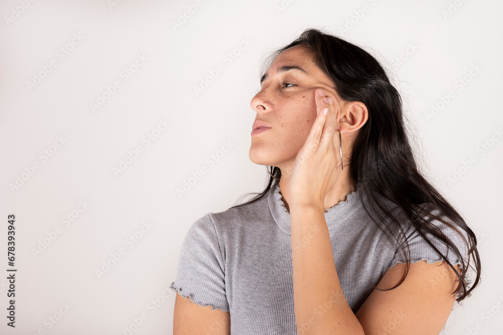 Beauty face. Black haired latin woman touching healthy skin on white background Beauty face. Black haired latin woman touching healthy skin on white background