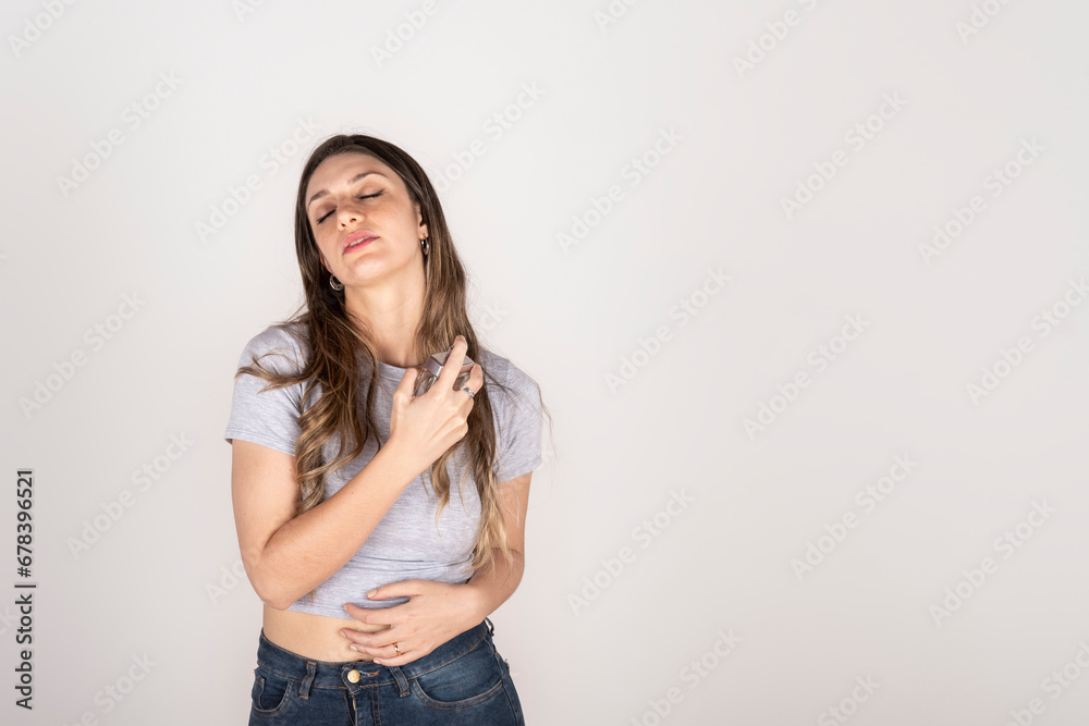 Blonde woman on white studio background putting on perfume Blonde woman on white studio background putting on perfume