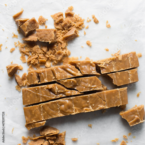 Crumbly Brown sugar fudge being cut on a marble tray, caramel fudge being cut into pieces, crumbly fudge candy on a marble tray photo