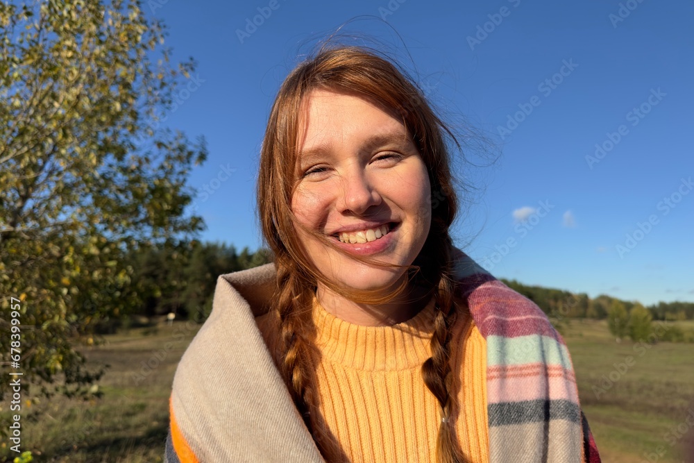 Portrait of happy positive young woman outdoors at park of forest at autumn sunny day 