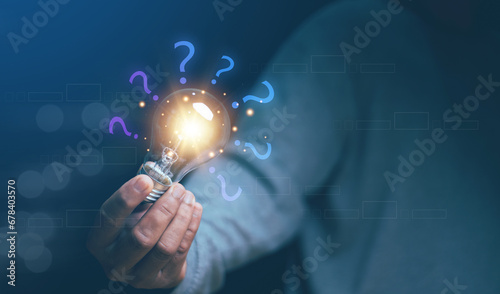 Creative thinking idea and problem solving concept, Man hand holding growing light bulb with question mark icon, New ideas and innovations arise and search for answers. photo