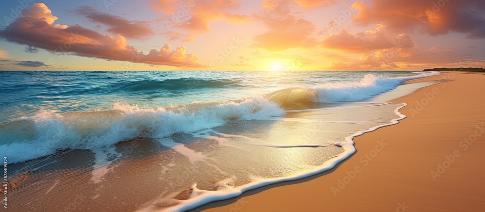 The beautiful summer beach landscape with its stunning blue ocean gentle waves and golden sunset creates a captivating background complemented by the texture of the sandy shore and the vastn