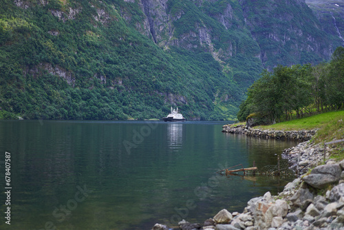 Small local ferry boat in the beautiful fjord during calm summer evening in Norway. Very common and neccesary kind of public boat transport in the norwegian fjords and between islands on the coast. photo
