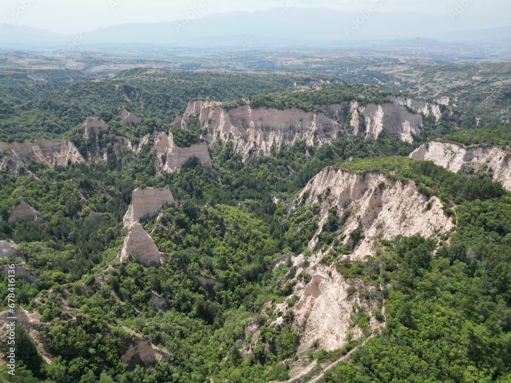 Aerial shot of the pyramids of Melnik and green trees on a summer day, Bulgaria