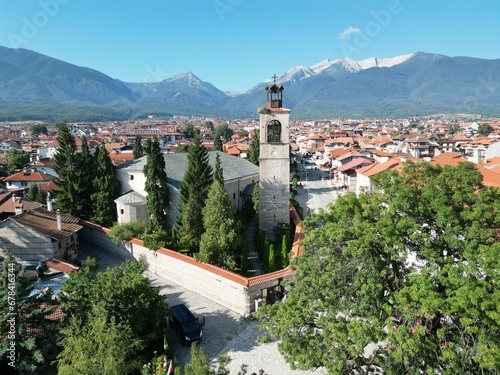 Aerial shot of Holy Trinity Church around houses and green trees in Bansko, Bulgaria photo
