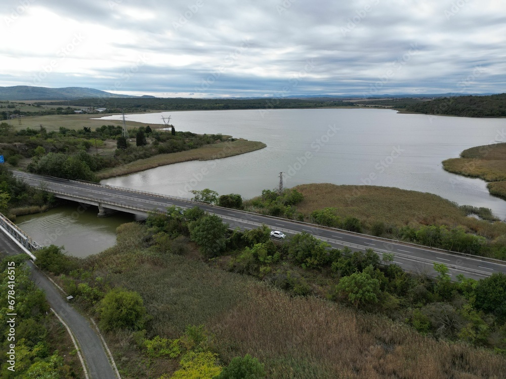 Aerial shot of roads along a wetland in a summer evening under the clouded sky