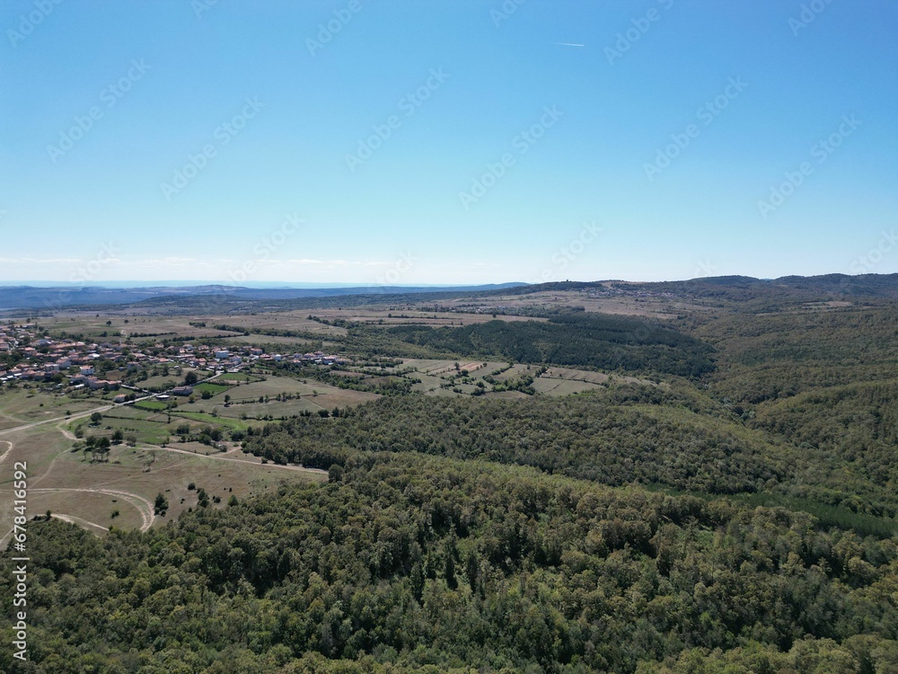 Aerial view of a town surrounded by green woods.