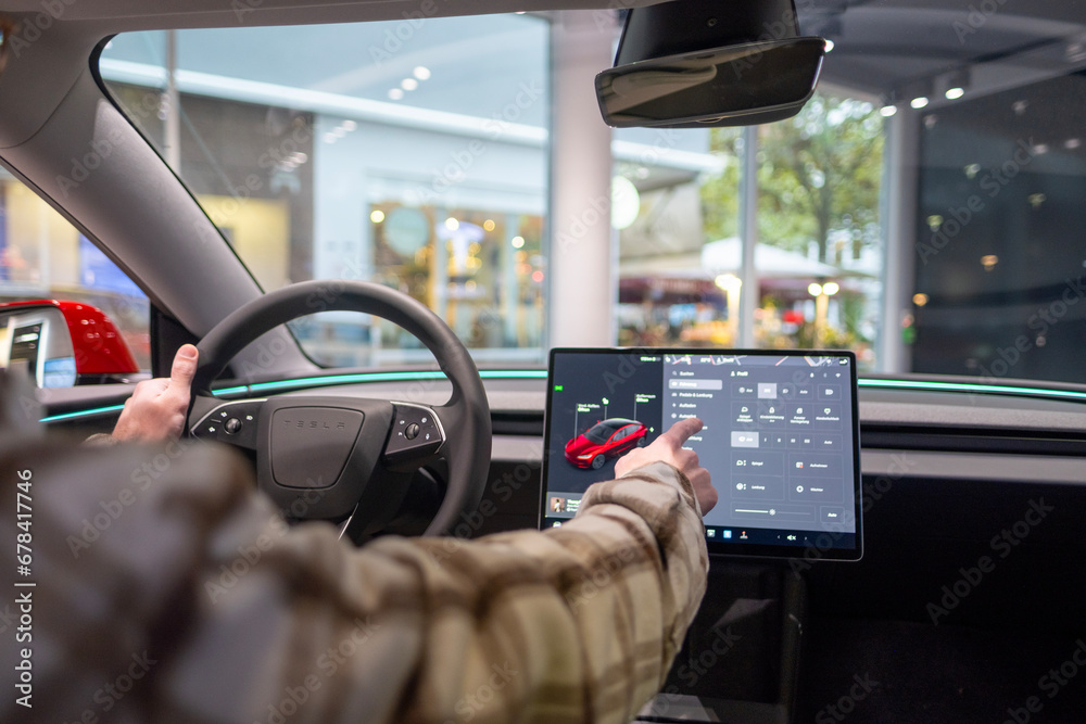 Tesla test drive, Young man, potential buyer, sits in car interior ...