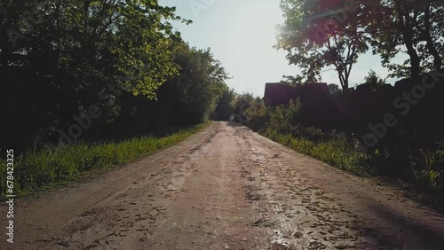 Rural dirt road with puddles on a summer sunny day. Camera movement forward.