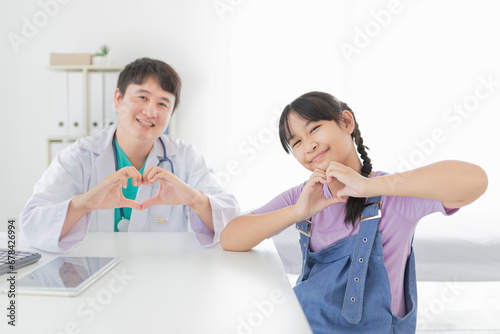 asian children patient and doctor show heart sign with hands together, happiness and relationship in hospital, they feeling happy and smile