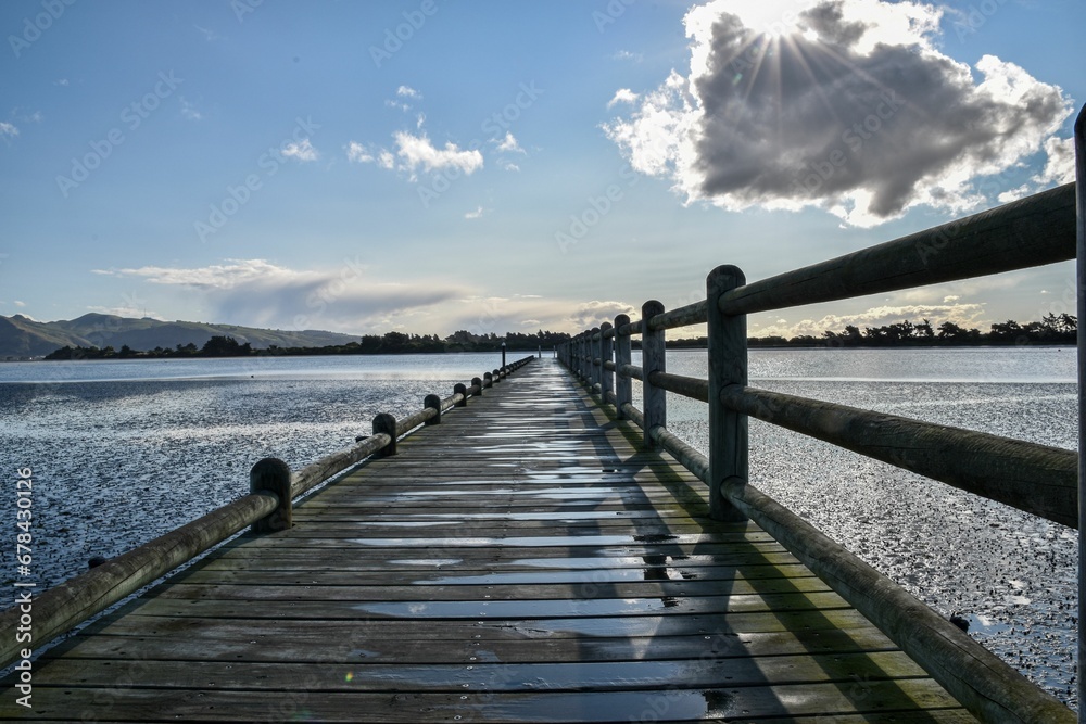 Wet wooden pier on the lake on sunny summer day
