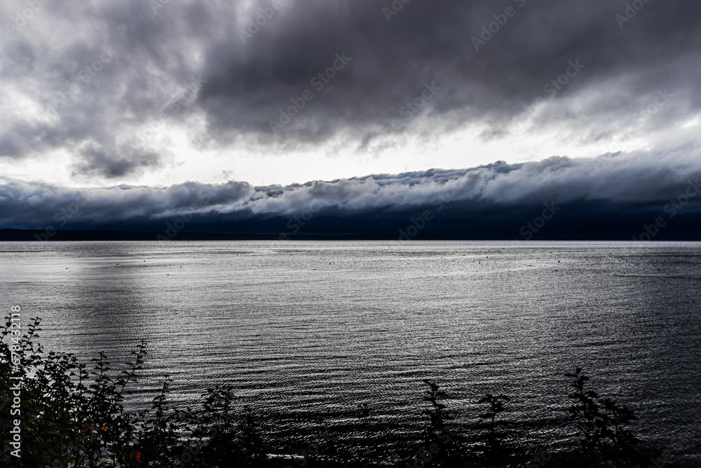 Dark lake landscape. Stormy weather scenic view. Melancholic landscape. Rainy day by the lake.