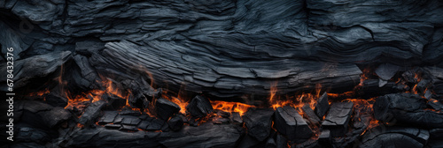 Black charcoal with fire, burnt wood texture background, panoramic banner. Abstract charred timber, pattern of embers. Concept of coal, bbq, grill, barbecue, fire, firewood, smoke photo