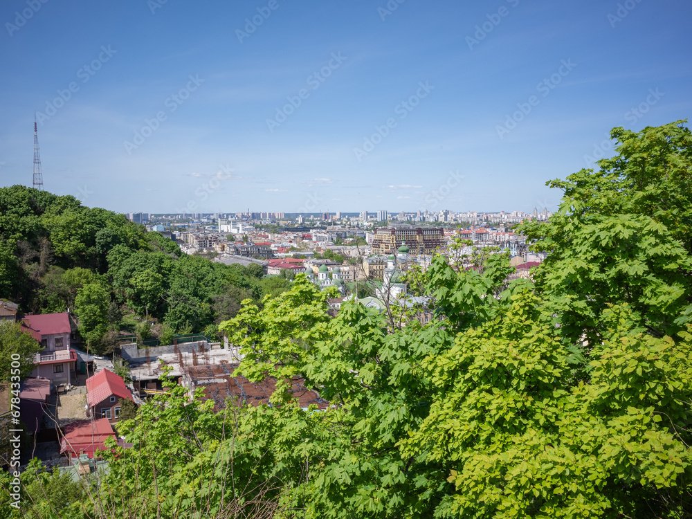 historical city scape of capital kyiv and green forest seen from the distance 