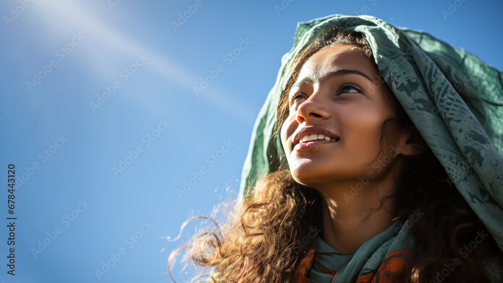 A Indian woman breathes calmly looking up isolated on clear blue sky A Indian woman breathes calmly looking up isolated on clear blue sky
