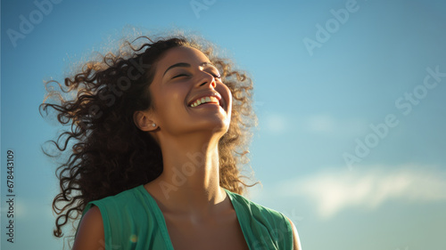 A Indian woman breathes calmly looking up isolated on clear blue sky