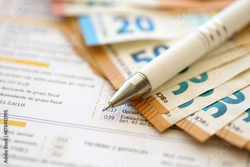 Filling italian tax form process with pen and euro money bills close up. Tax paying period and deadline