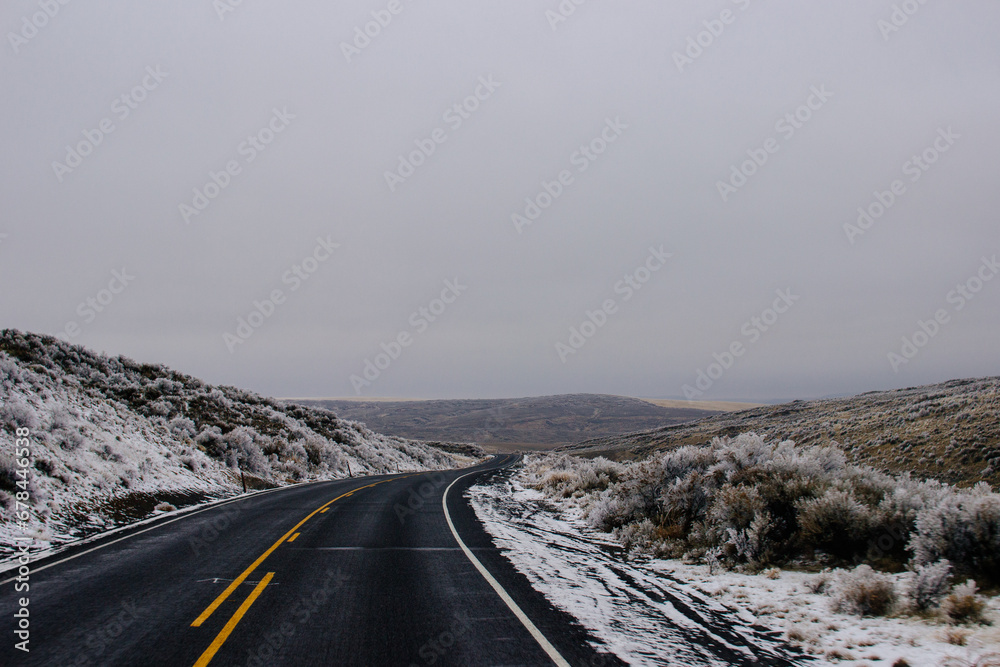 Asphalt Road in the middle of a mountainous area covered with frost, with cozy houses on a winter cloudy day. American landscape Asphalt Road in the middle of a mountainous area covered with frost, with cozy houses on a winter cloudy day. American landscape