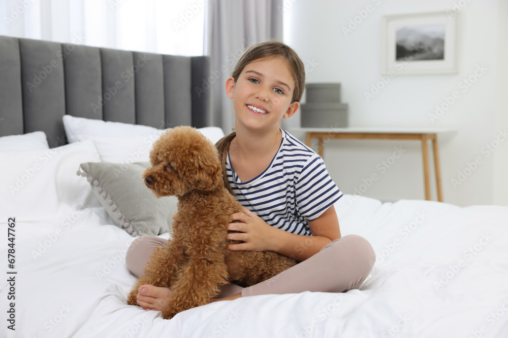 Little child with cute puppy on bed at home. Lovely pet Little child with cute puppy on bed at home. Lovely pet