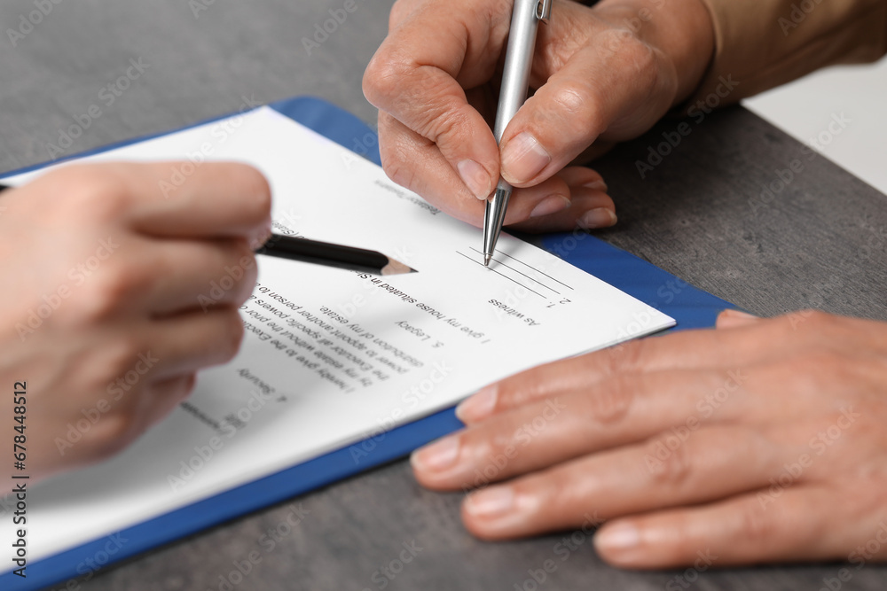 Manager showing client where she must to mark signature at dark table, closeup Manager showing client where she must to mark signature at dark table, closeup