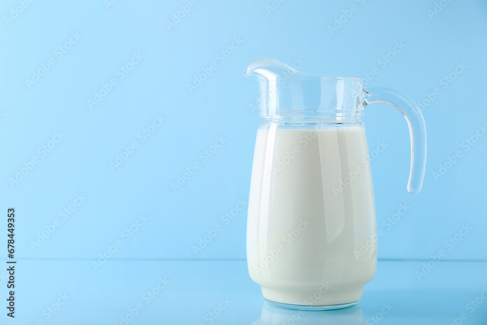 Jug of fresh milk on light blue background, space for text Jug of fresh milk on light blue background, space for text