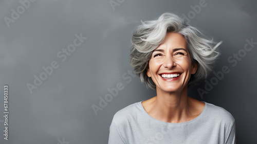 happy silver hair white 50's woman grey background 