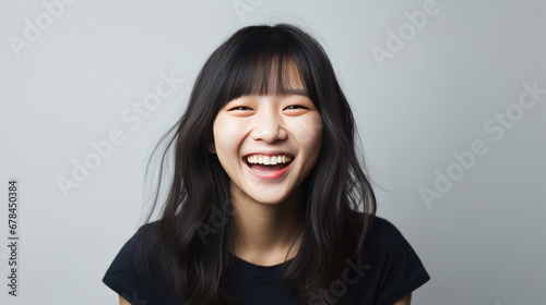 portrait of a happy asian long hair woman on grey background 