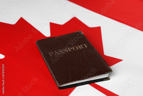 Immigration to Canada. Passport on flag, closeup