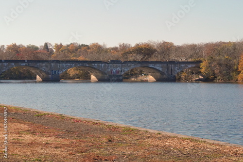 Arched Stone and Cement Bridge over a River in Fall with Blue Sky