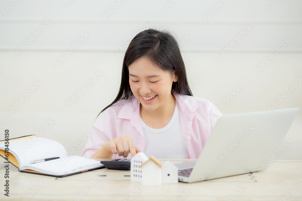 Young asian woman sitting and planning and calculate expense and mortgage with calculator and home on desk, insurance and budget of residential, loan and residence, business and property concept. Young asian woman sitting and planning and calculate expense and mortgage with calculator and home on desk, insurance and budget of residential, loan and residence, business and property concept.