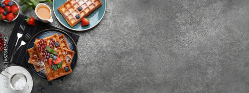 Delicious Belgian waffles with fresh berries served on grey table, flat lay. Banner design with space for text