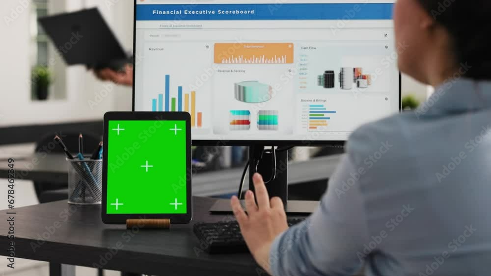 Specialist works with greenscreen tablet in open floor plan office, presenting isolated display on modern device. Businesswoman using pc monitor and blank chromakey layout on mini screen. Specialist works with greenscreen tablet in open floor plan office, presenting isolated display on modern device. Businesswoman using pc monitor and blank chromakey layout on mini screen.