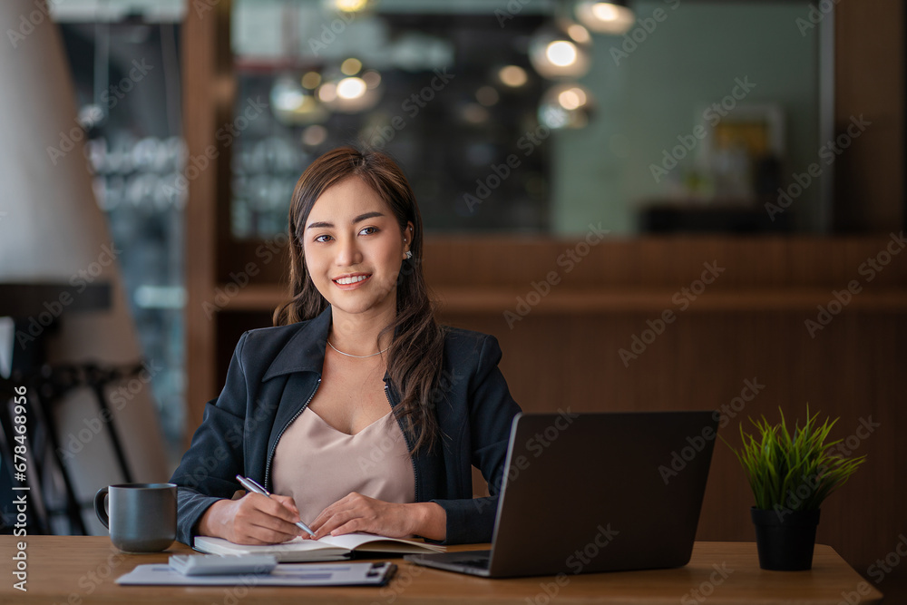 Ambitious Asian girl working from home Looking at laptop screen and financial documents, woman is checking email or doing research while working remotely. Ambitious Asian girl working from home Looking at laptop screen and financial documents, woman is checking email or doing research while working remotely.