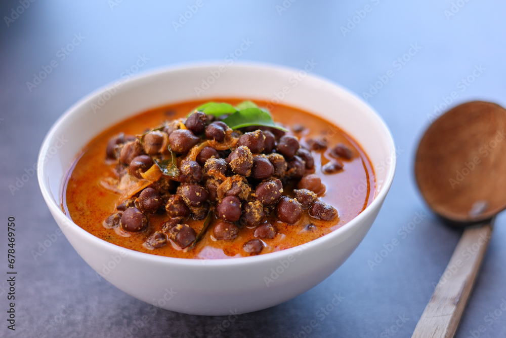 Bowl of delicious Kadala curry or chana masala curry or chick pea curry in white bowl with white background. Kerala breakfast side dish for appam puttu rice. kala chana desi chana whole bengal gram Bowl of delicious Kadala curry or chana masala curry or chick pea curry in white bowl with white background. Kerala breakfast side dish for appam puttu rice. kala chana desi chana whole bengal gram