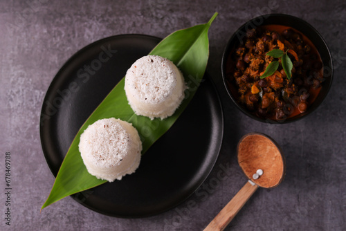 Popular South Indian breakfast puttu / pittu made of rice flour and coconut with banana and kadala curry, Kerala breakfast, India. Bamboo puttu prepared in steam photo