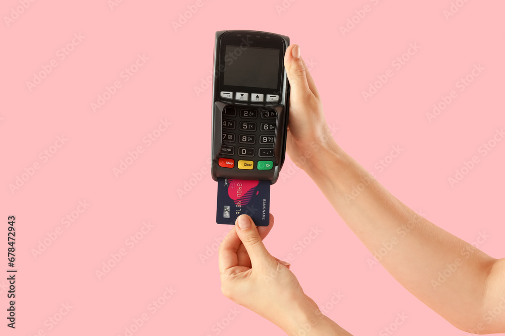 Young woman paying with credit card via terminal on pink background, closeup Young woman paying with credit card via terminal on pink background, closeup