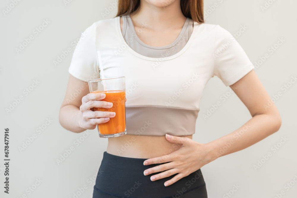 Orange detox juice, good digestive, young woman hand on stomach, belly with glass of vegetable juice, carrot smoothie for diet, girl drinking healthy meal food for weight loss isolated on background. Orange detox juice, good digestive, young woman hand on stomach, belly with glass of vegetable juice, carrot smoothie for diet, girl drinking healthy meal food for weight loss isolated on background.