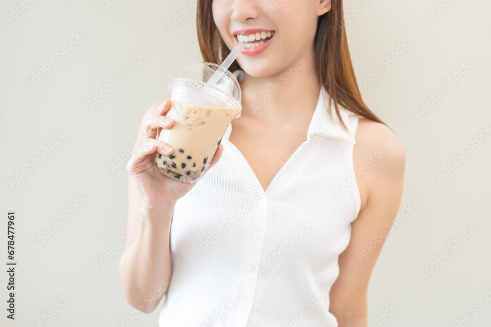 Beverage and food concept, Happy asian young woman hand holding plastic cup, glass of drink bubble, pearl milk tea with straw, cute girl drinking ice cold tea with tapioca boba ball popular in Taiwan. Beverage and food concept, Happy asian young woman hand holding plastic cup, glass of drink bubble, pearl milk tea with straw, cute girl drinking ice cold tea with tapioca boba ball popular in Taiwan.