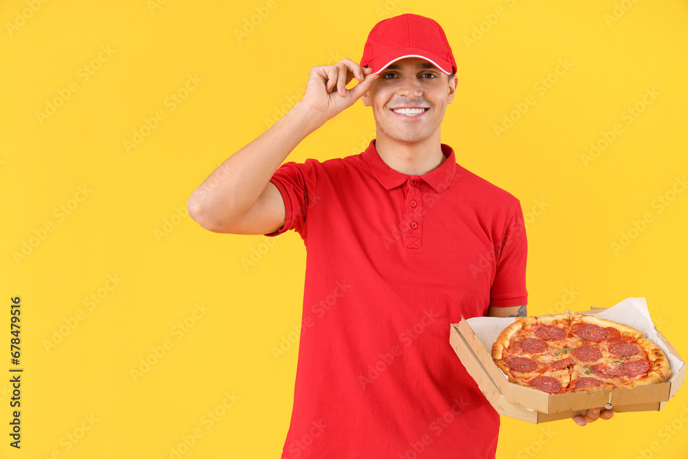 Male courier with tasty pepperoni pizza on yellow background Male courier with tasty pepperoni pizza on yellow background
