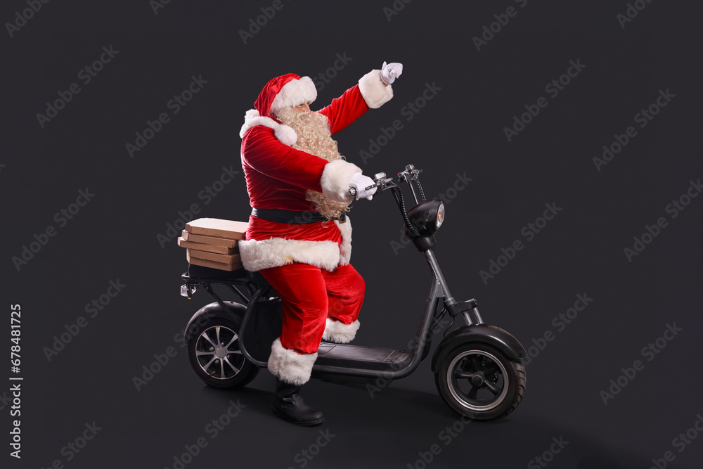 Santa Claus with pizza boxes on bike against dark background Santa Claus with pizza boxes on bike against dark background