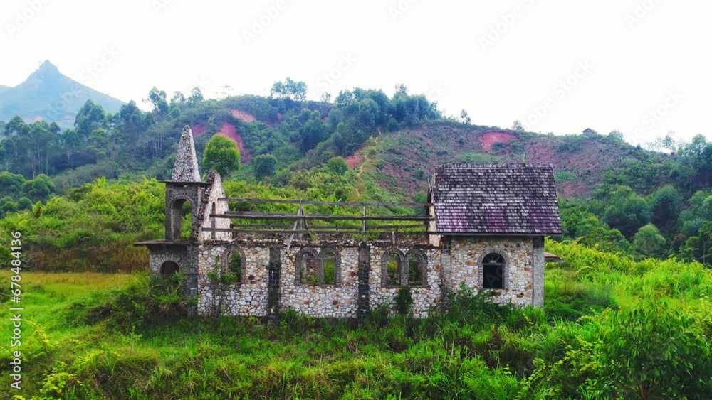 Close up of old empty building in the green jungle. Tropical forest behind the destroyed church made of stones. Aerial shot. Close up of old empty building in the green jungle. Tropical forest behind the destroyed church made of stones. Aerial shot.