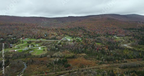 Aerial view of residential area near colorful fall forest on hillside photo