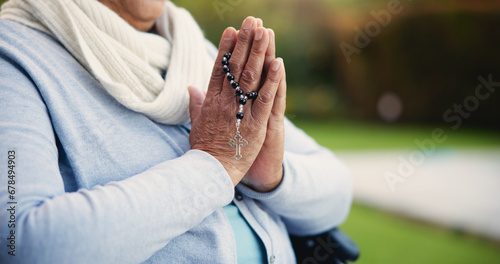 Senior, woman or hands praying with rosary for religion, worship and support for jesus christ in garden of home. Elderly, person and prayer beads for thank you, gratitude and trust in God for praise photo