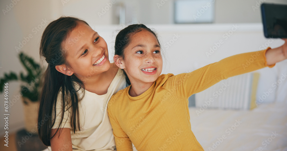 Selfie, sister and happy with girl children in the bedroom of their home together for a social media profile picture. Family, smile and sibling kids on a bed in their apartment to update a status Selfie, sister and happy with girl children in the bedroom of their home together for a social media profile picture. Family, smile and sibling kids on a bed in their apartment to update a status