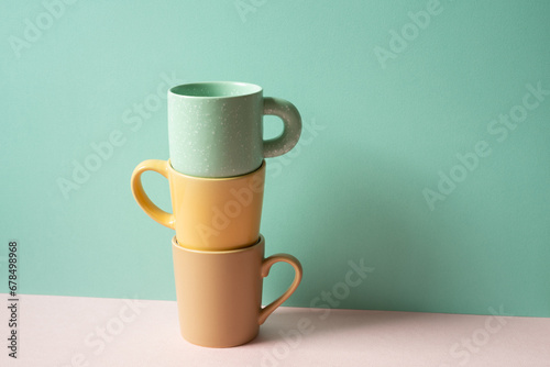 Stack of mug cup on pink table. mint green wall background