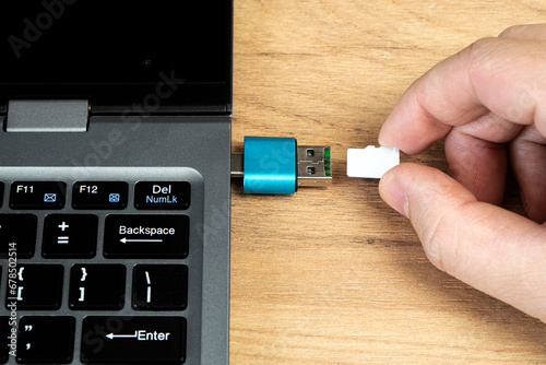 usb flash drive adapter micro sd card connection to laptop. micro sd card in man's hand photo