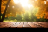 Wooden table with bokeh autumn leaves on nature forest background. Mock up for display of product. High quality photo. 