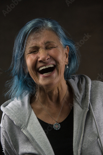 portrait of a radiant senior woman lost in a moment of infectious laughter. Blue-dyed hair youthful spirit ageless beauty