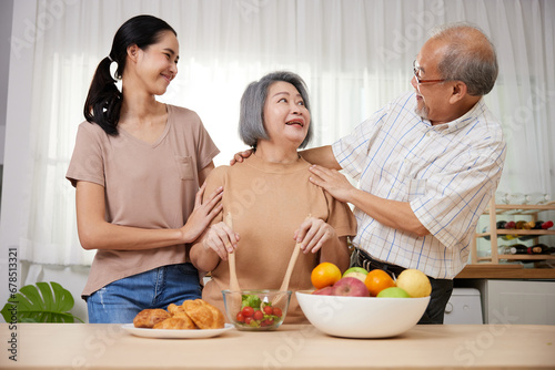 asian family senior couple and granddaughter enjoy cooking salad in the kitchen