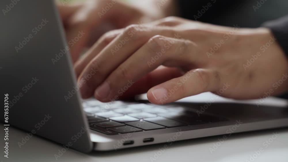 The man's hand is typing on a laptop computer keyboard at home or in the office. He is working, sending messages, chatting, browsing the internet, and using social networking. The man's hand is typing on a laptop computer keyboard at home or in the office. He is working, sending messages, chatting, browsing the internet, and using social networking.